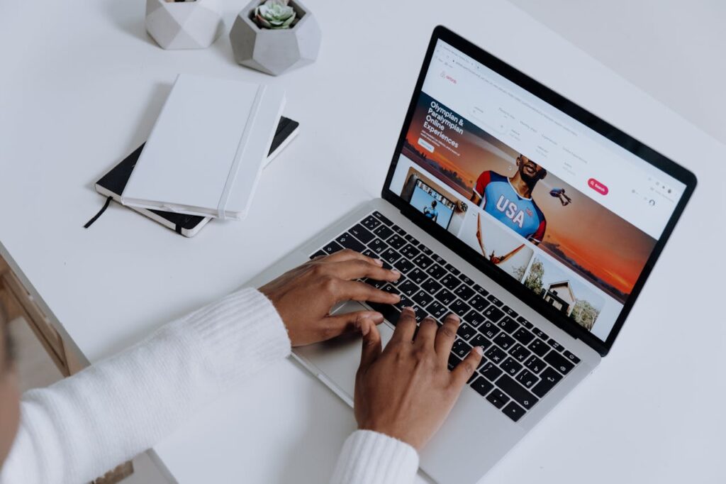 Person Using a Macbook Pro on a White Table